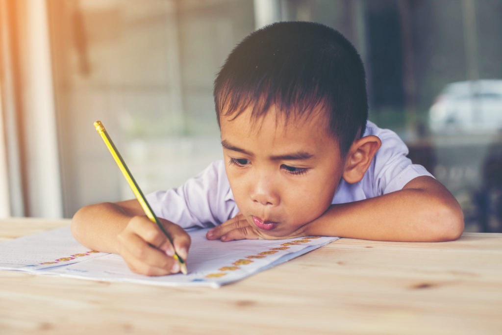 Милый мальчик делает. Doing his homework.